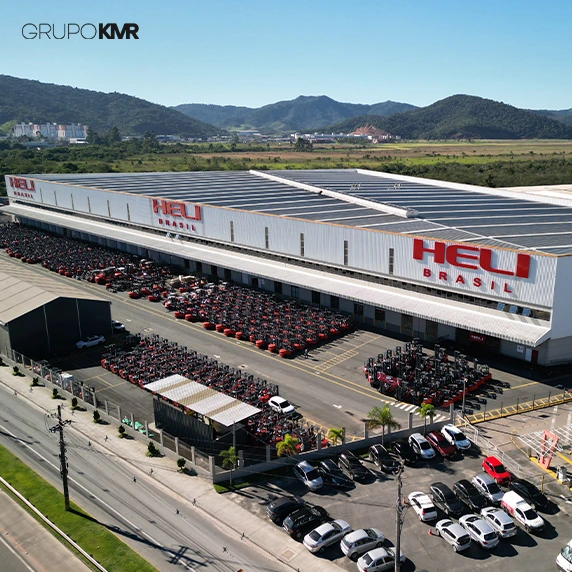 Empilhadeira vermelha e preta em galpão industrial com peças organizadas